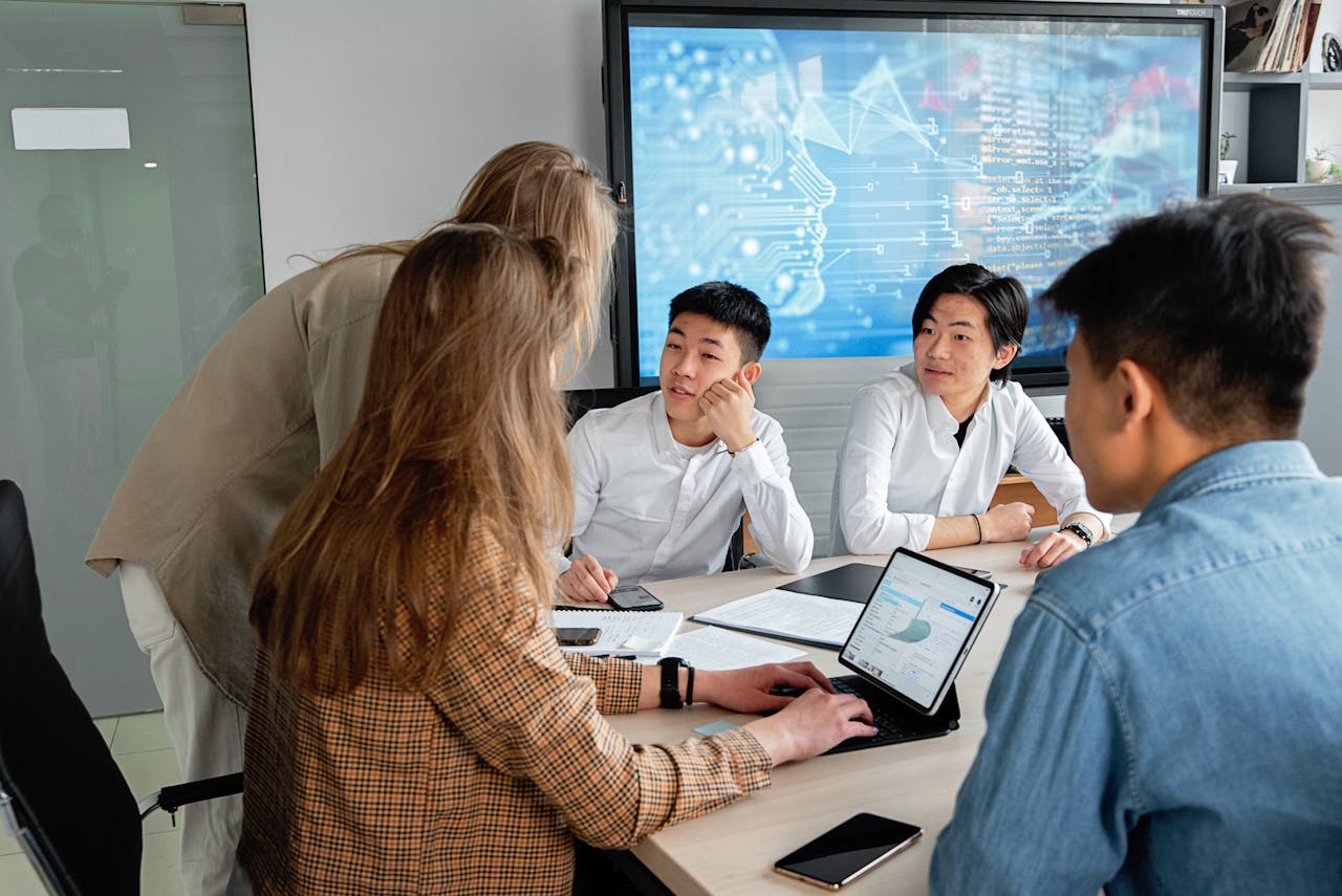 services-02 Team of professionals collaborating in an office with digital interface on background screen.